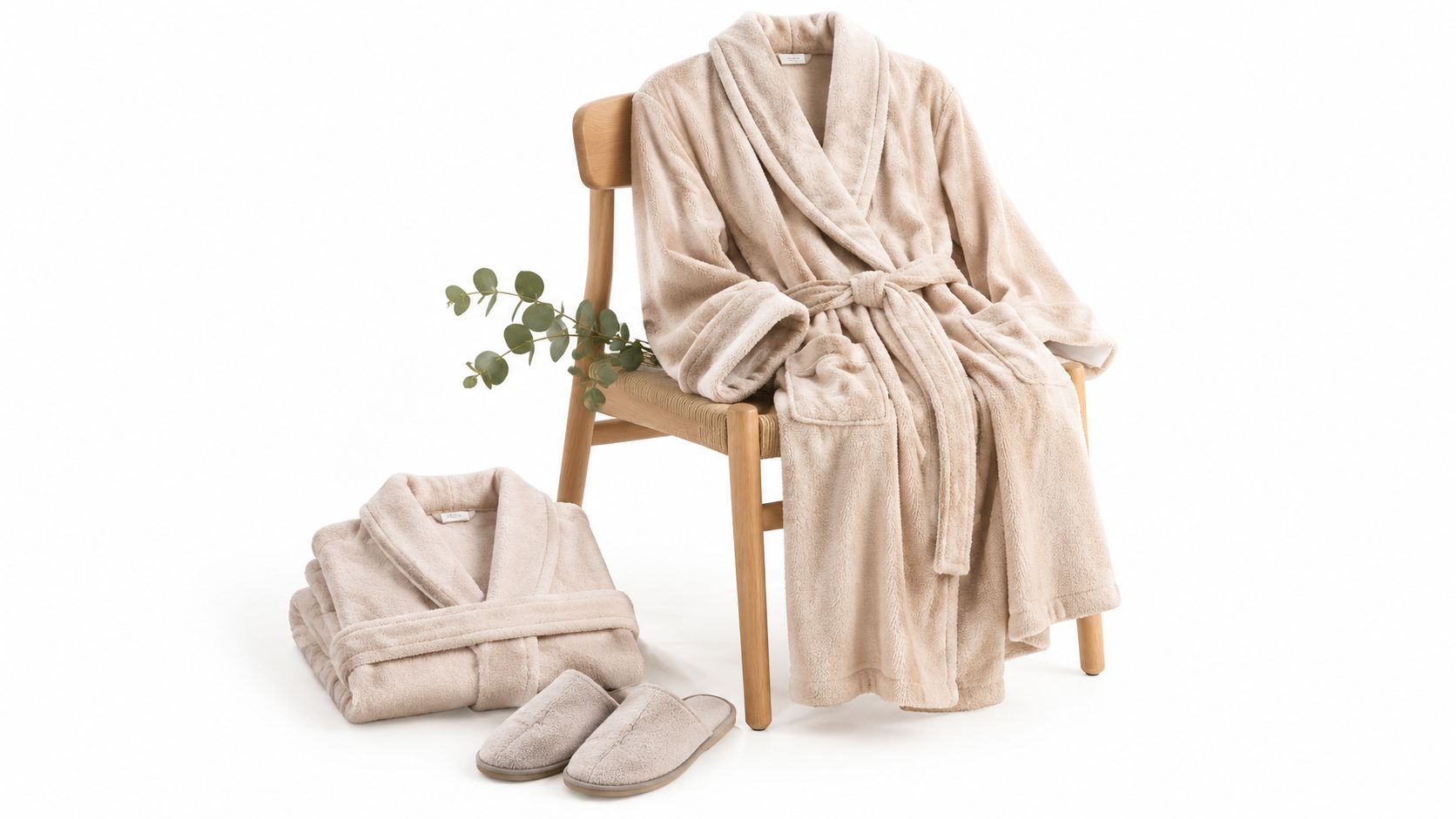 A cozy beige maternity bathrobe set with matching slippers and a small decorative plant on a wooden chair.